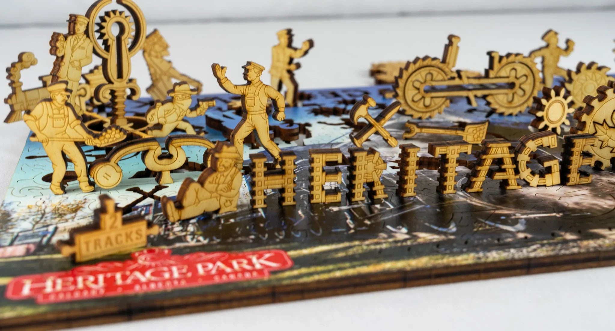 Wooden Heritage Park puzzle with laser-cut figures of workers, gears, trains, and the word HERITAGE.