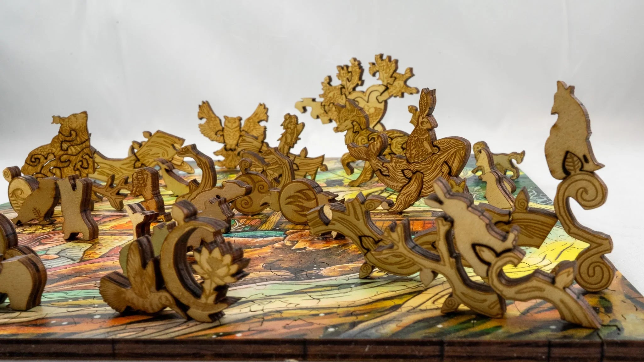 Laser-cut wooden animal puzzle pieces on a colorful board with whimsical shapes
