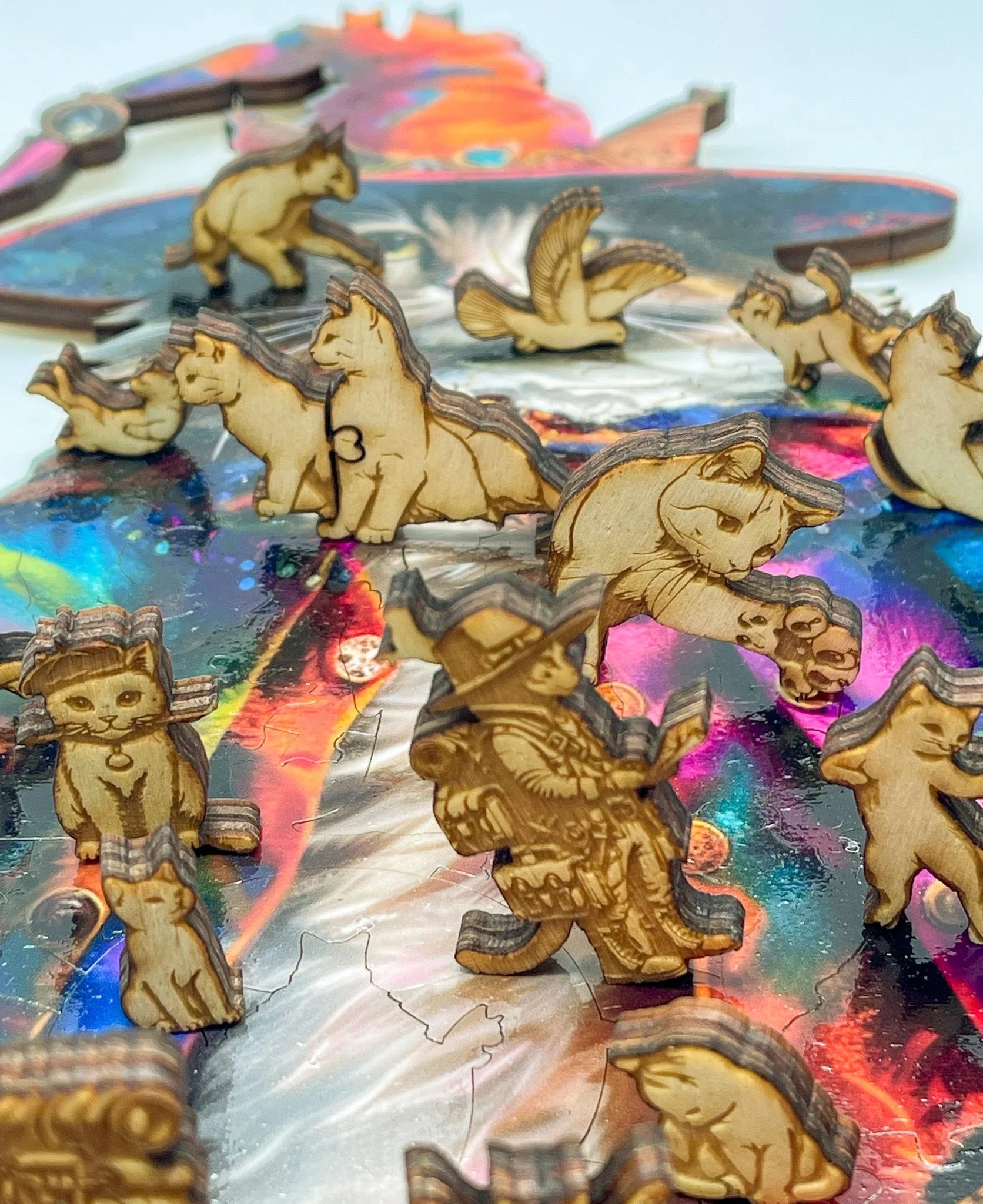 Laser-cut wooden cat puzzle pieces on a colorful, iridescent background
