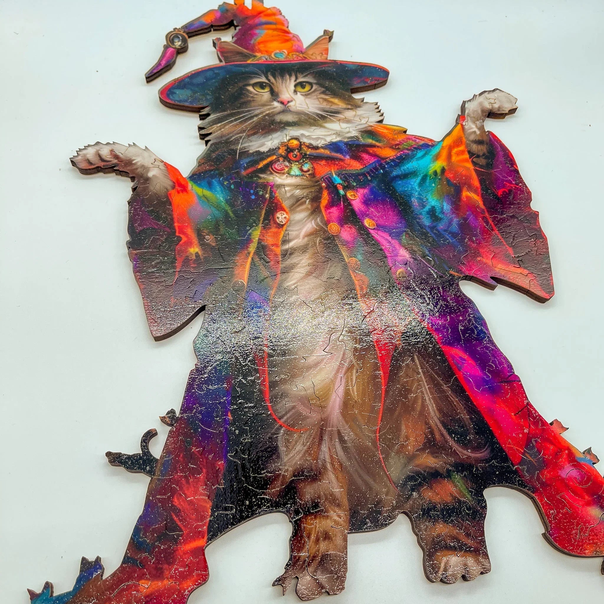 Wooden puzzle of a cat in a colorful wizard costume and hat on a white background