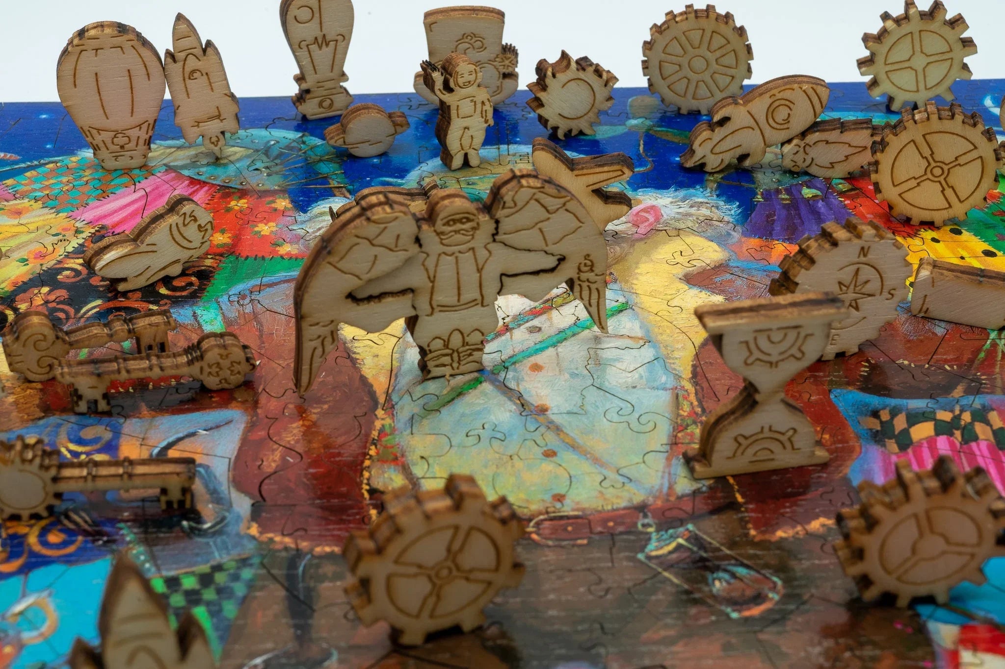 Laser-cut wooden steampunk puzzle pieces on a colorful jigsaw puzzle background