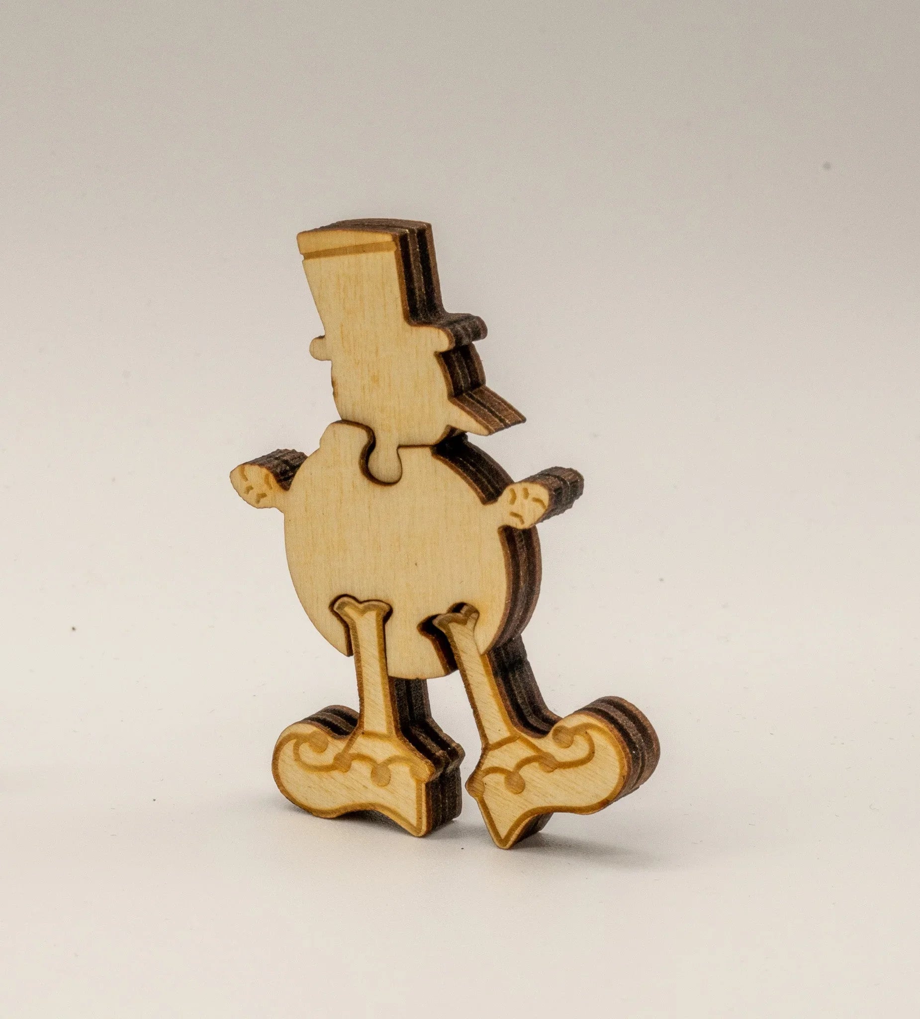 Laser-cut wooden duck puzzle piece with hat, standing on white background