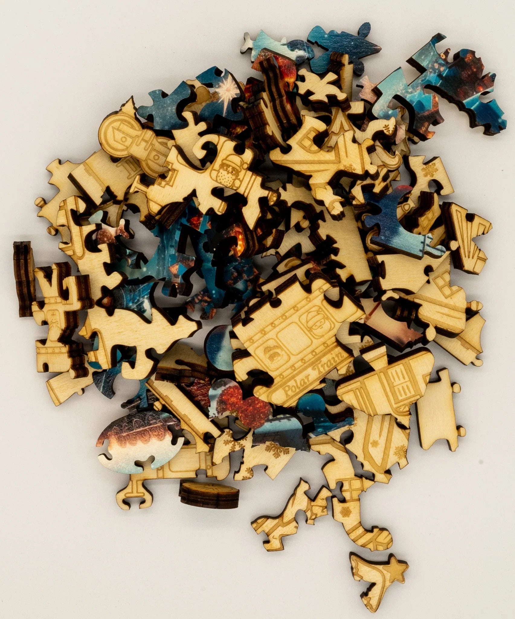 Wooden jigsaw puzzle pieces with engraved designs and colorful images on a white background