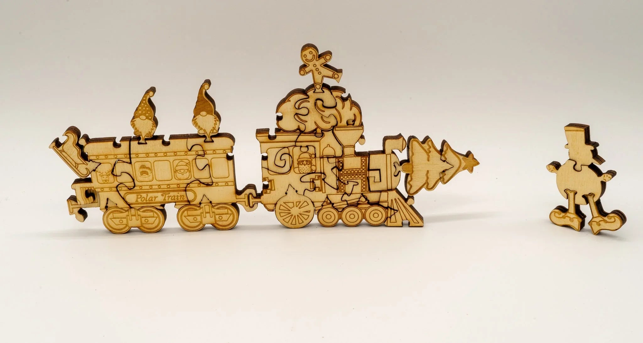 Wooden Polar Train Christmas puzzle with gnome, gingerbread, and tree pieces on white background