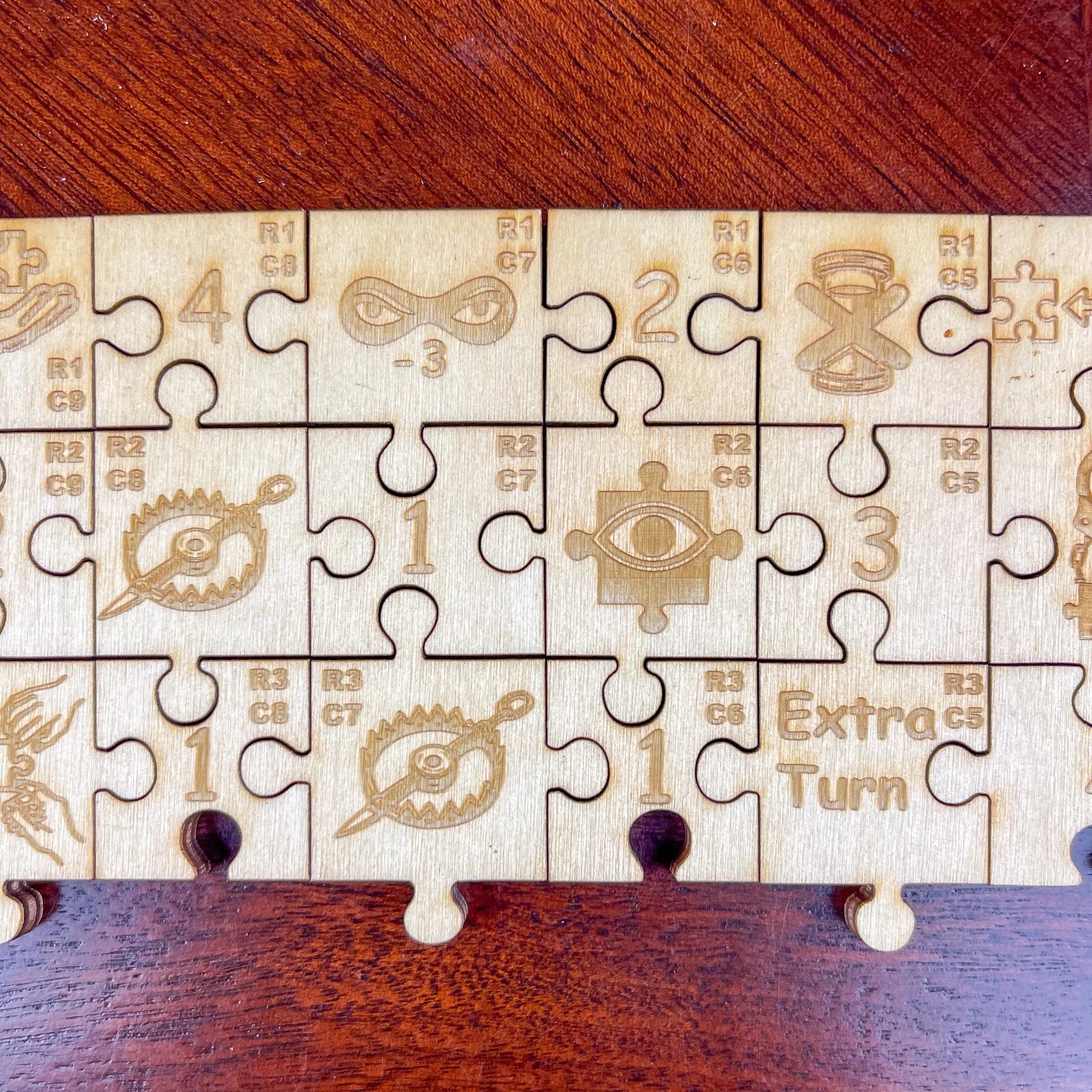 Wooden puzzle pieces with engraved symbols, numbers, and text on a wood surface.