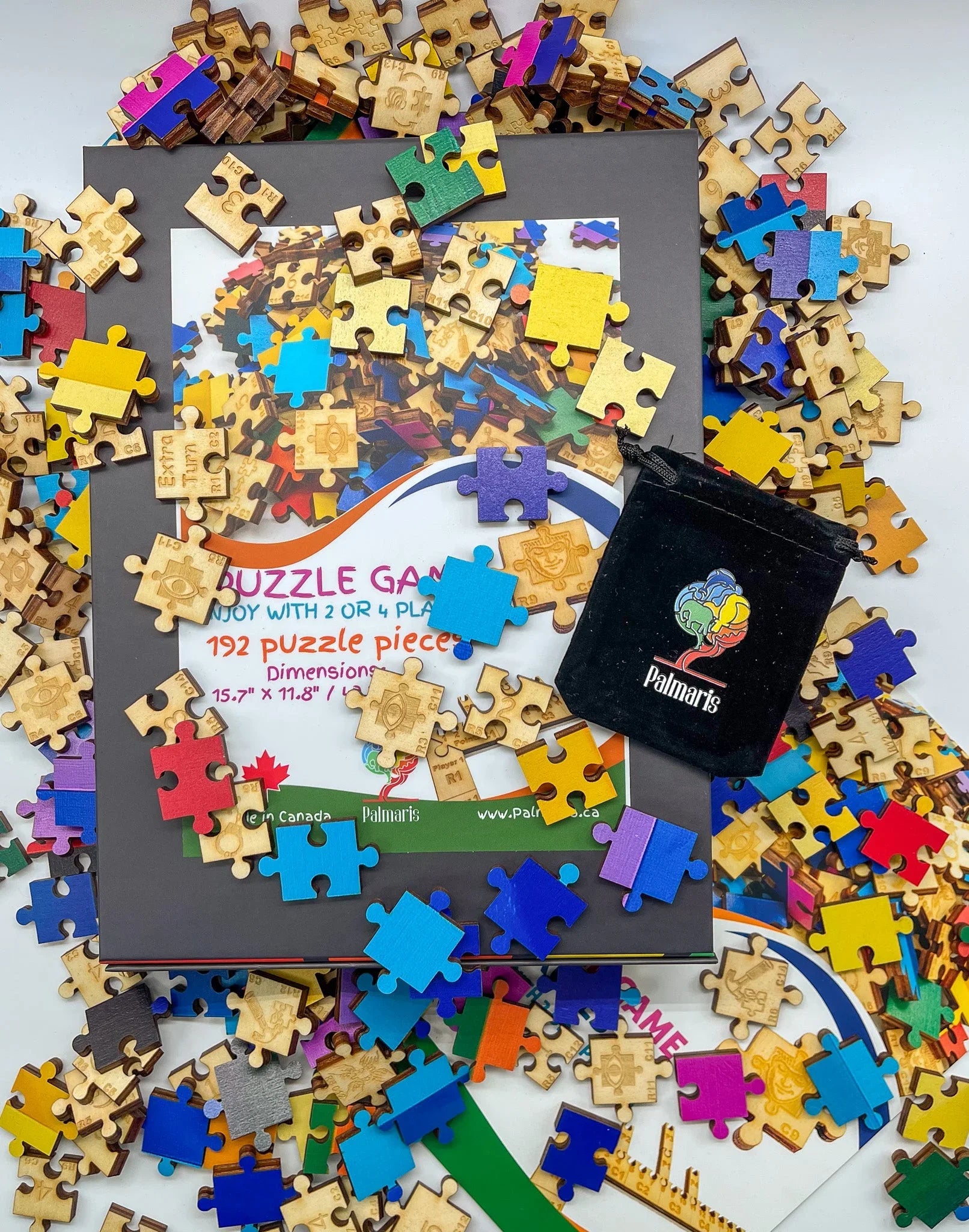 Colorful wooden puzzle pieces scattered on a puzzle game box with Palmaris pouch