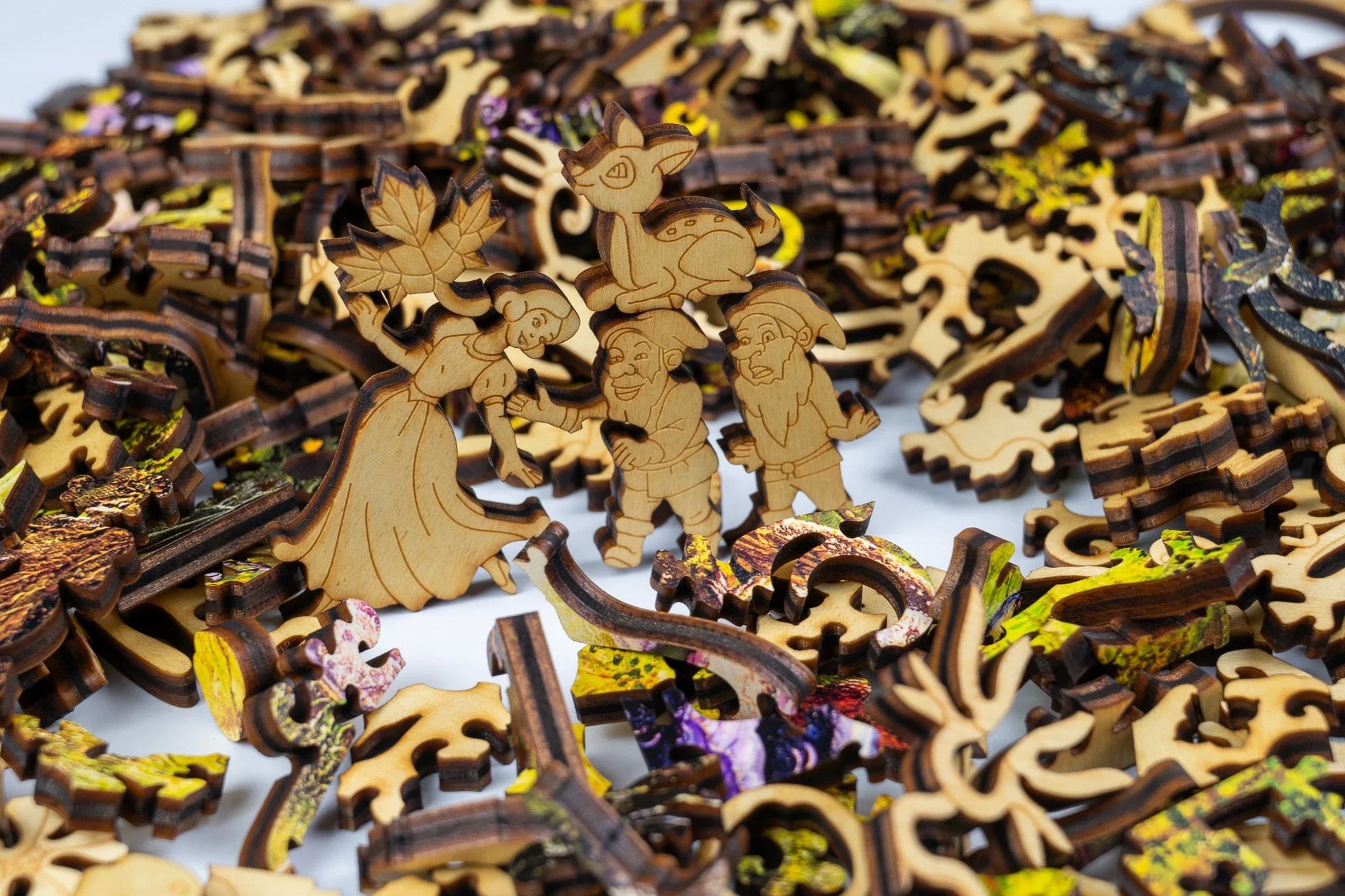 Wooden fairy tale puzzle pieces with engraved characters and animals on white background