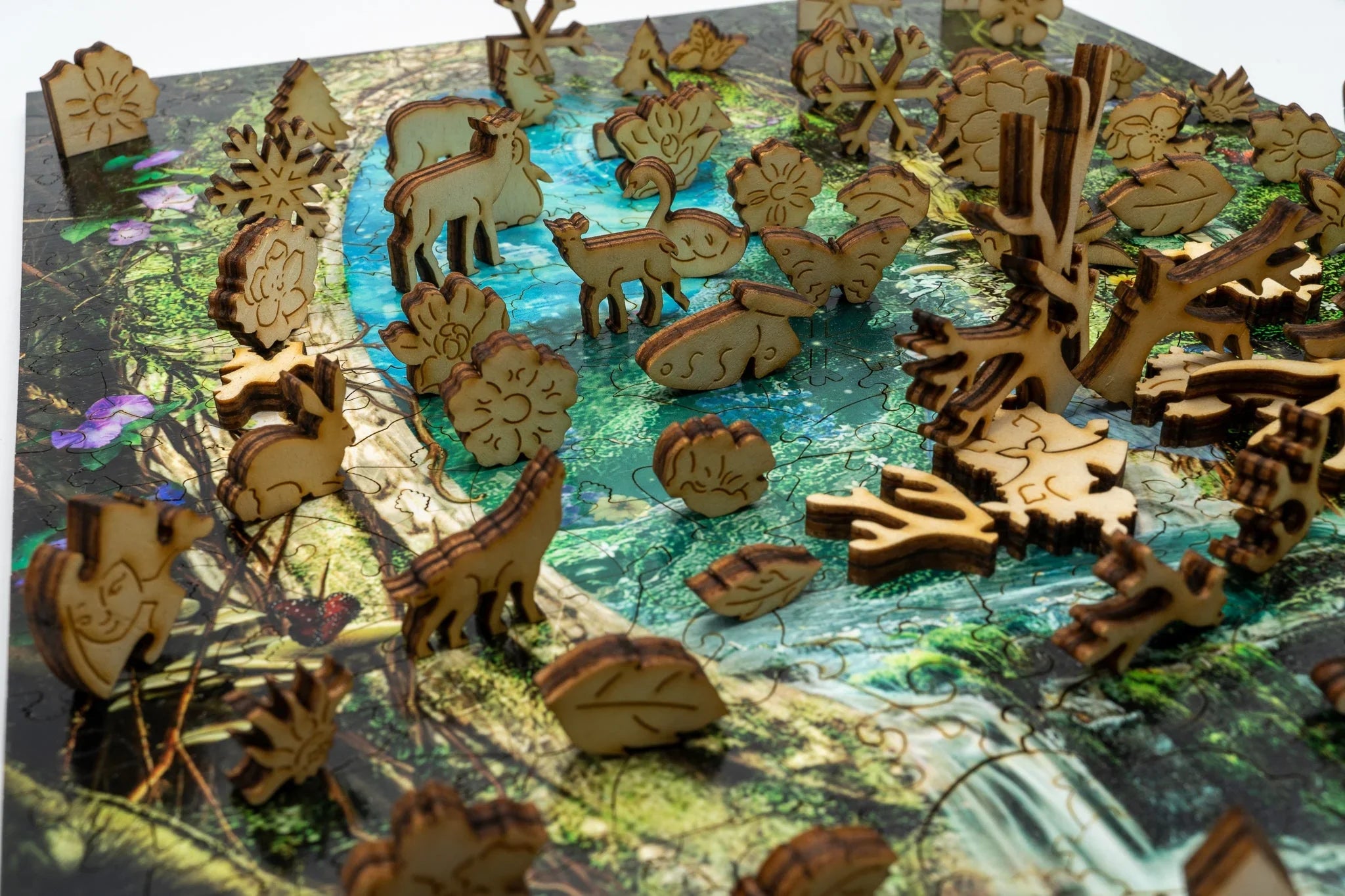 Wooden animal puzzle pieces on a nature puzzle with river, forest, and trees