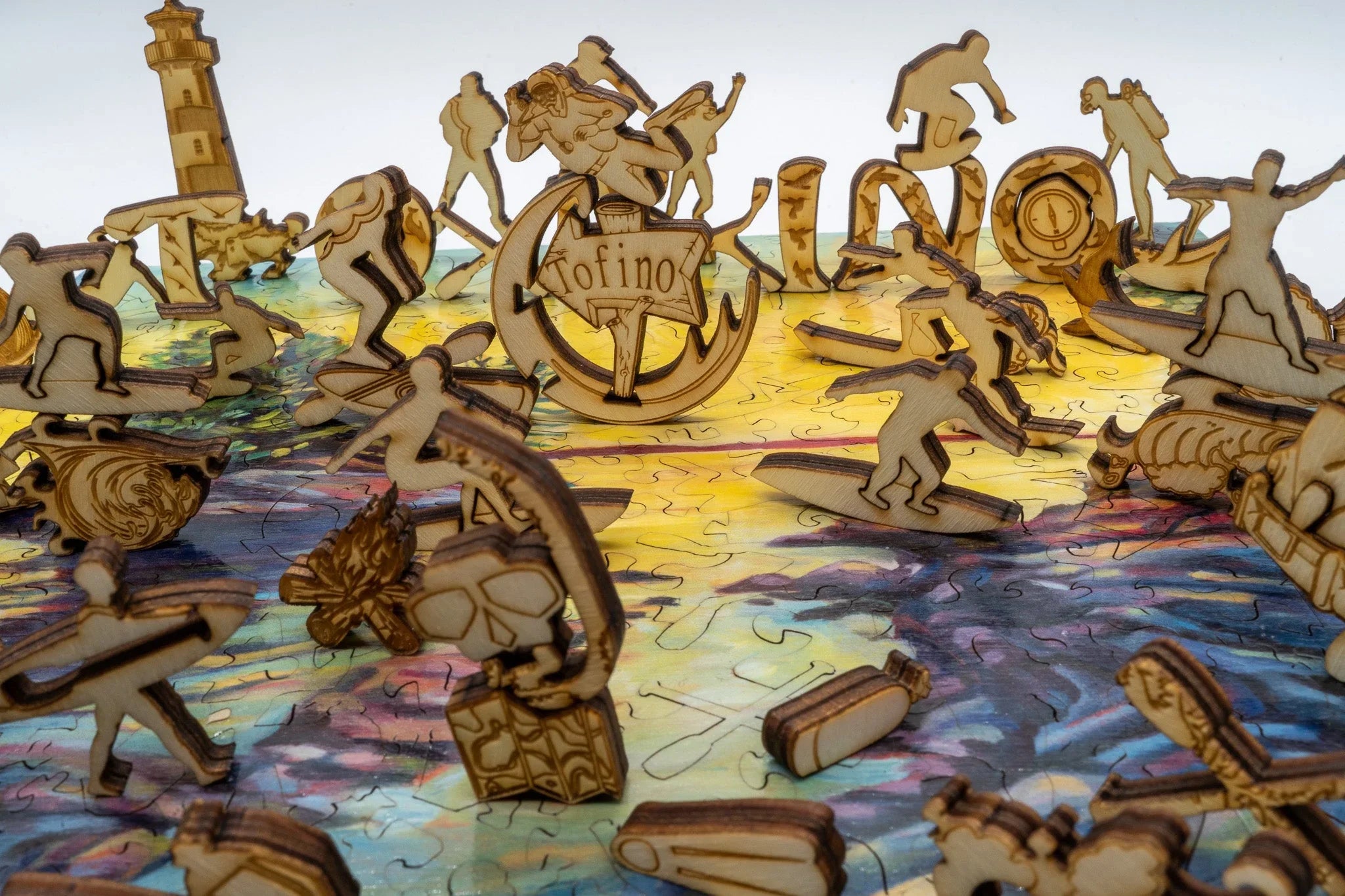 Laser-cut wooden surfer puzzle pieces on colorful ocean-themed background, Tofino sign center