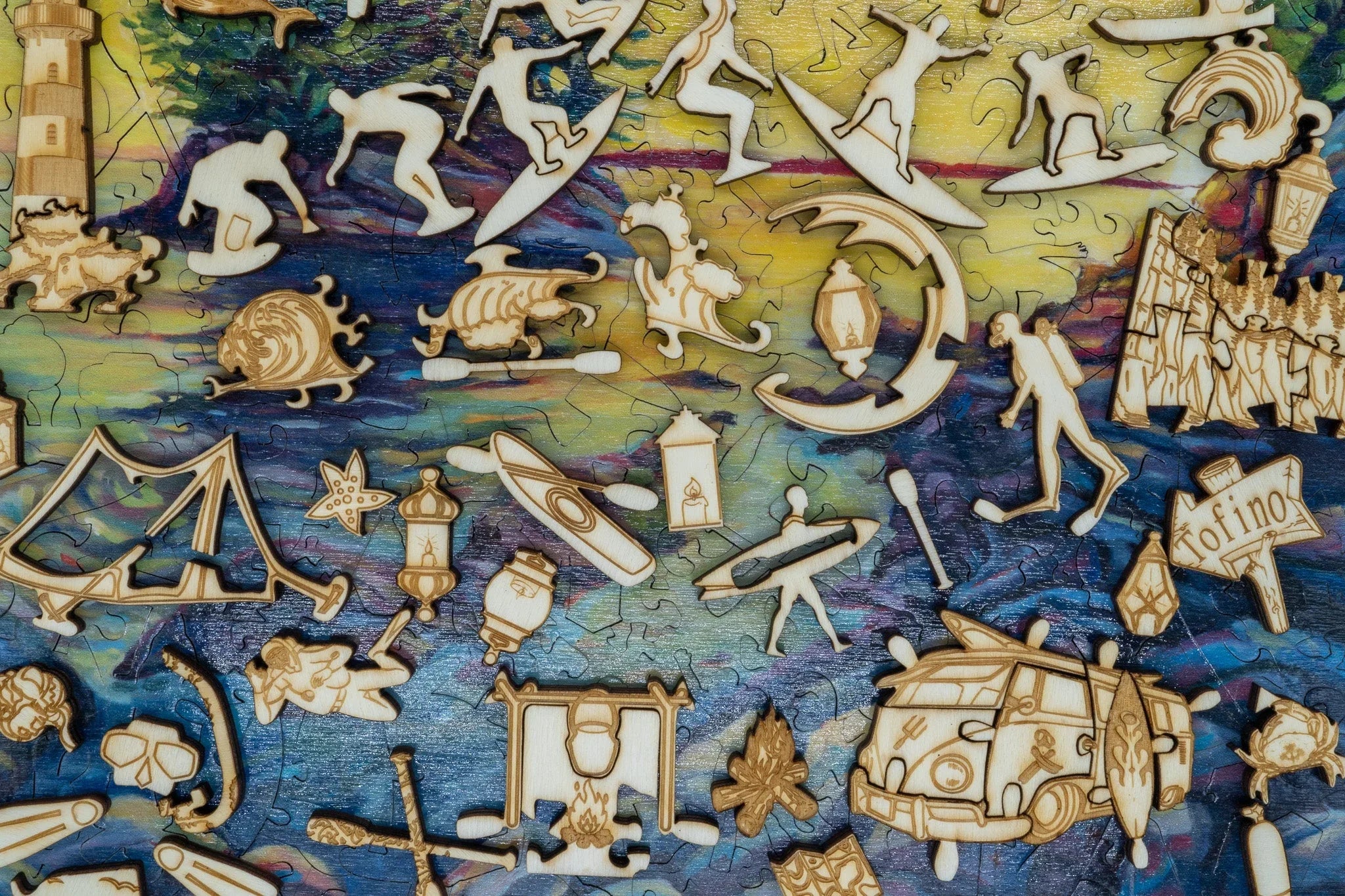 Colorful puzzle with wooden pieces shaped like surfers, kayaks, lighthouse, and Tofino van
