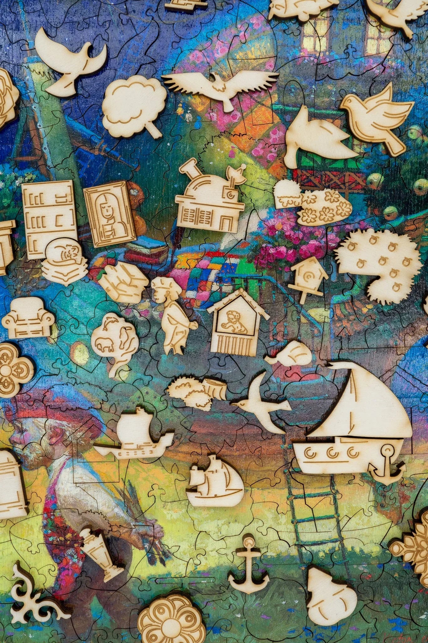 Colorful jigsaw puzzle with wooden whimsical pieces, birds, ships, flowers and painter