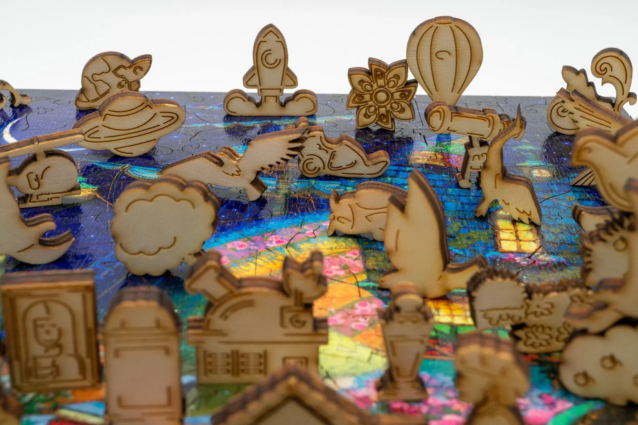 Laser-cut wooden puzzle pieces in various shapes on a colorful jigsaw puzzle surface