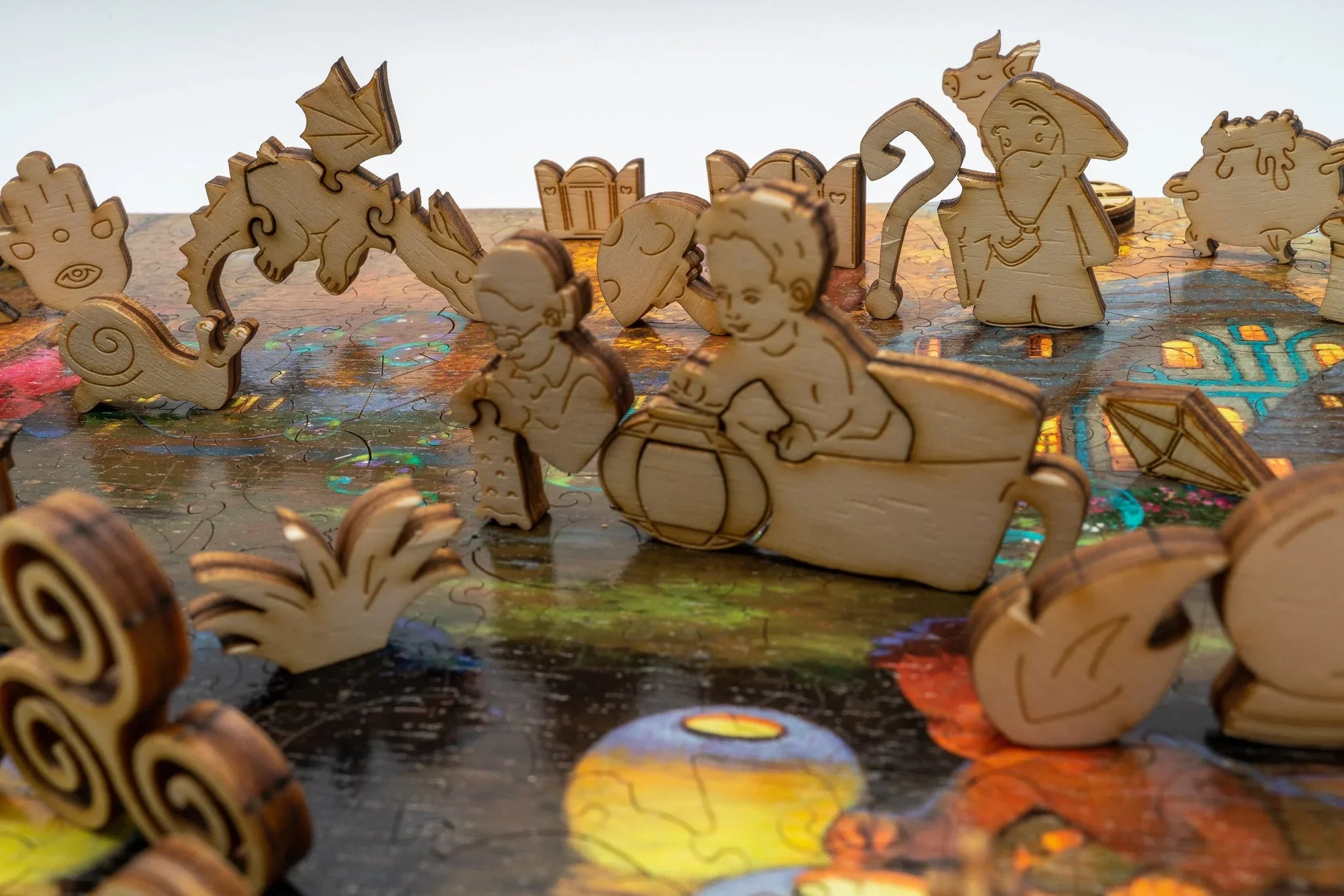 Wooden fantasy puzzle pieces on a colorful board, including dragon, wizard, and child shapes