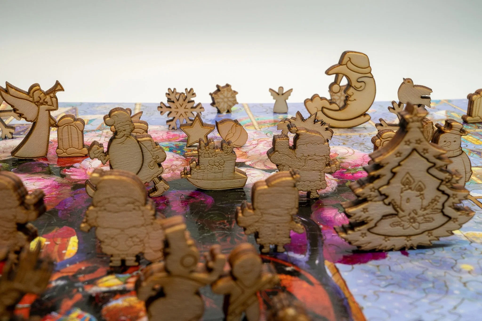 Wooden Christmas puzzle pieces shaped like Santa, trees, and snowflakes on a colorful board