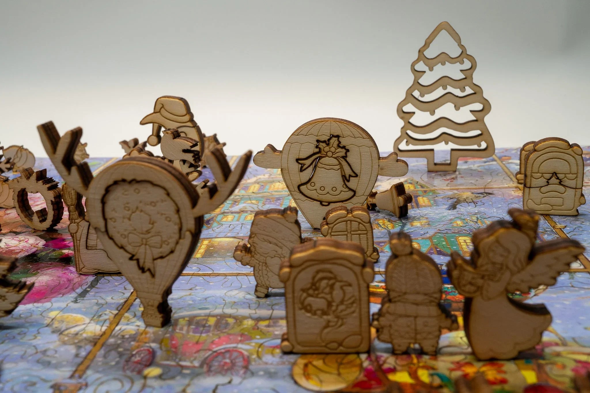 Wooden Christmas puzzle pieces with festive designs on a colorful puzzle background