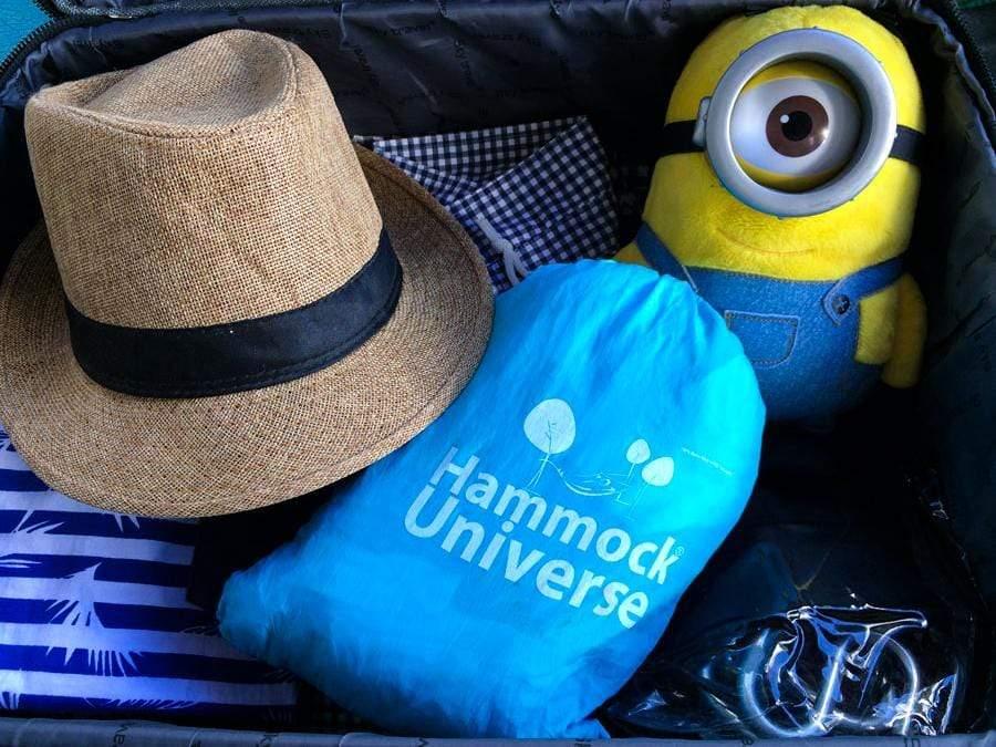 Hammock Universe blue travel hammock in suitcase with straw hat and yellow plush toy