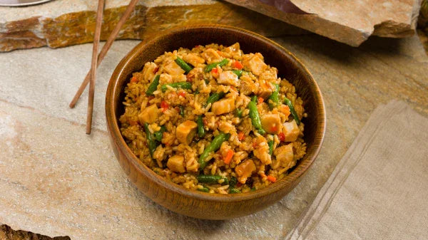 Chicken teriyaki rice bowl with vegetables in a wooden bowl on stone countertop