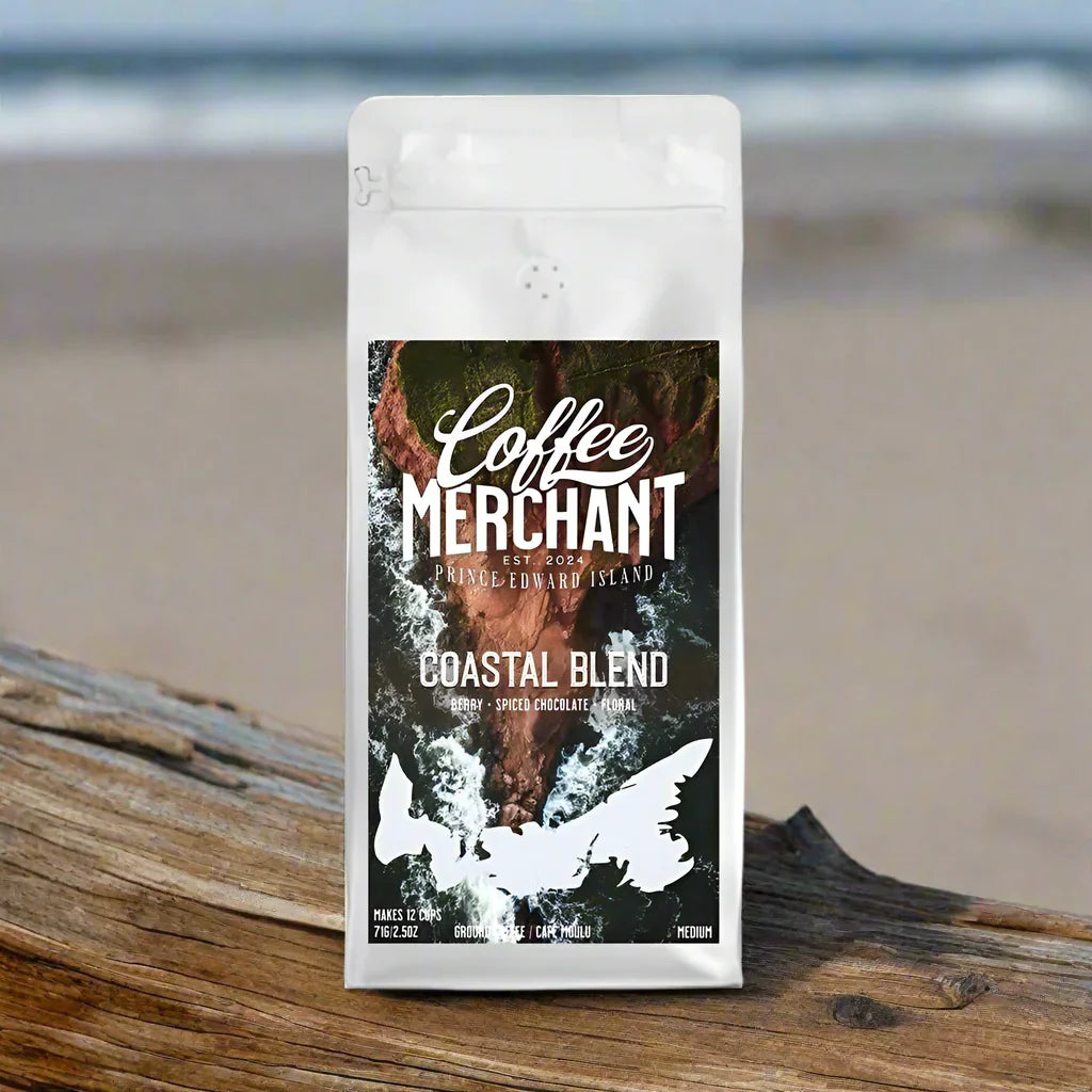Coastal Blend Coffee Merchant Prince Edward Island coffee bag on driftwood at the beach.