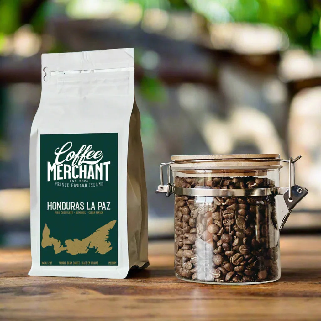 Honduras La Paz whole bean coffee bag and glass jar of coffee beans on wood table