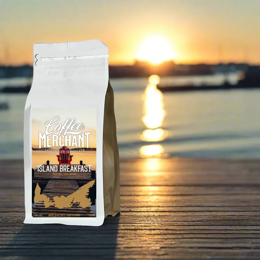 Coffee Merchant Island Breakfast coffee bag on a wooden dock at sunrise by the water.
