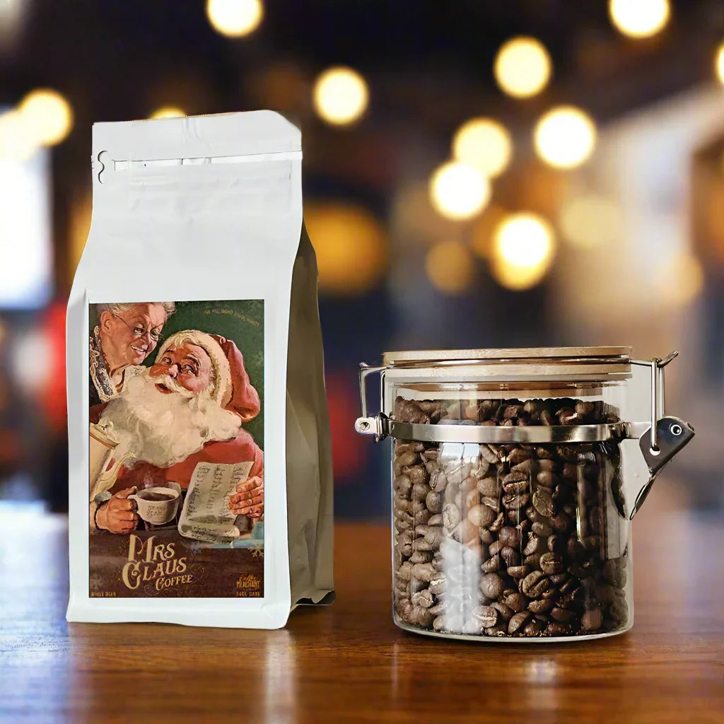 Mrs Claus Coffee bag with Santa illustration beside a glass jar of coffee beans on table