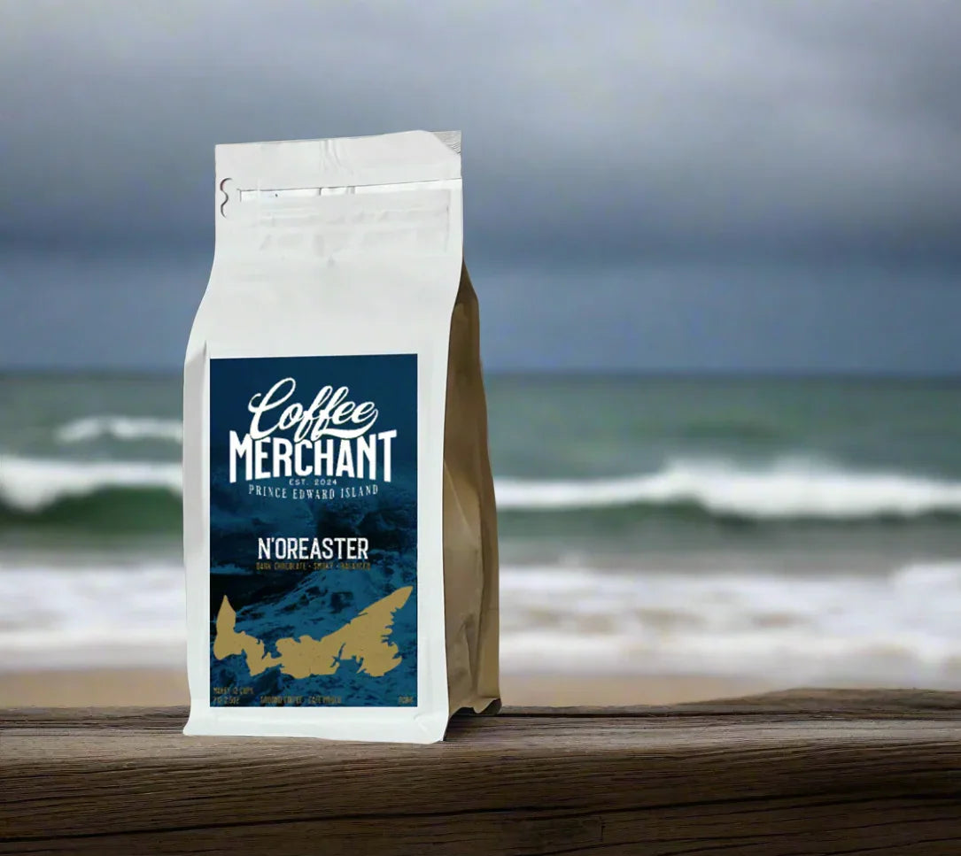Coffee Merchant Prince Edward Island N'oreaster coffee bag on beach with ocean waves