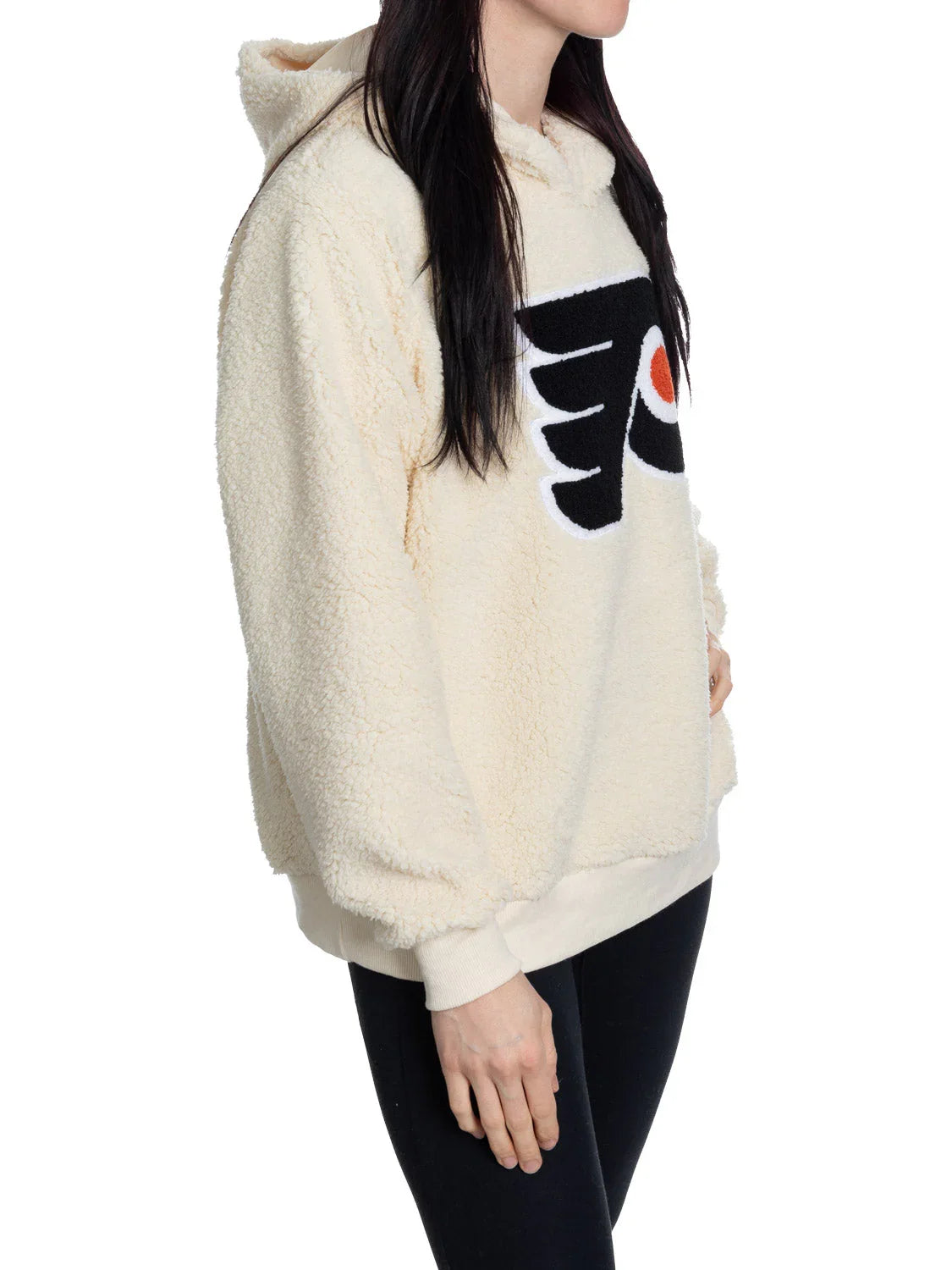 Woman wearing cream sherpa hoodie with Philadelphia Flyers logo, side view