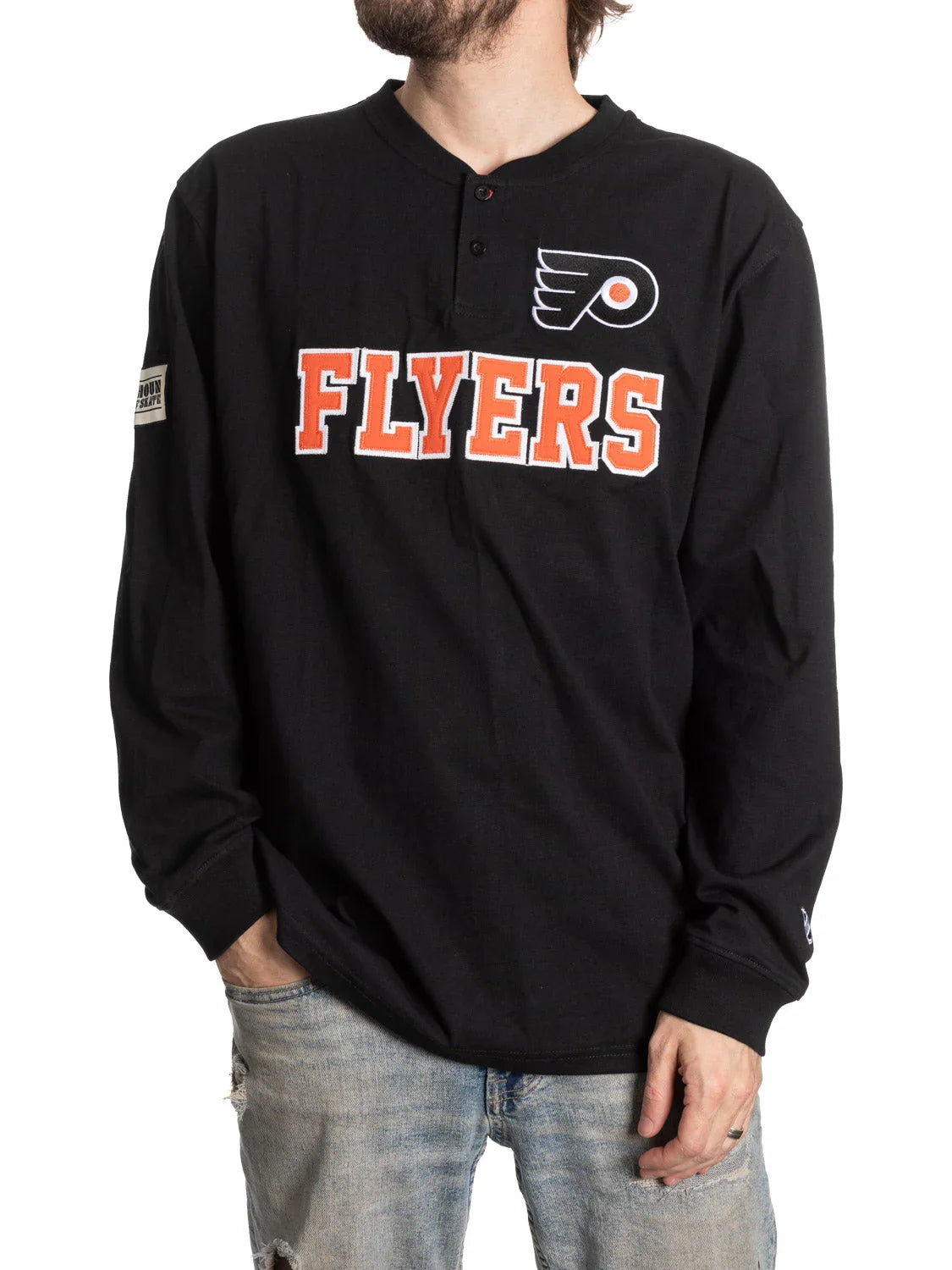 Man wearing black Philadelphia Flyers henley shirt and distressed jeans