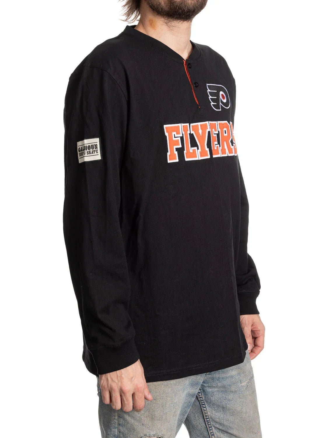 Man wearing black Philadelphia Flyers long sleeve Henley shirt with logo and jeans
