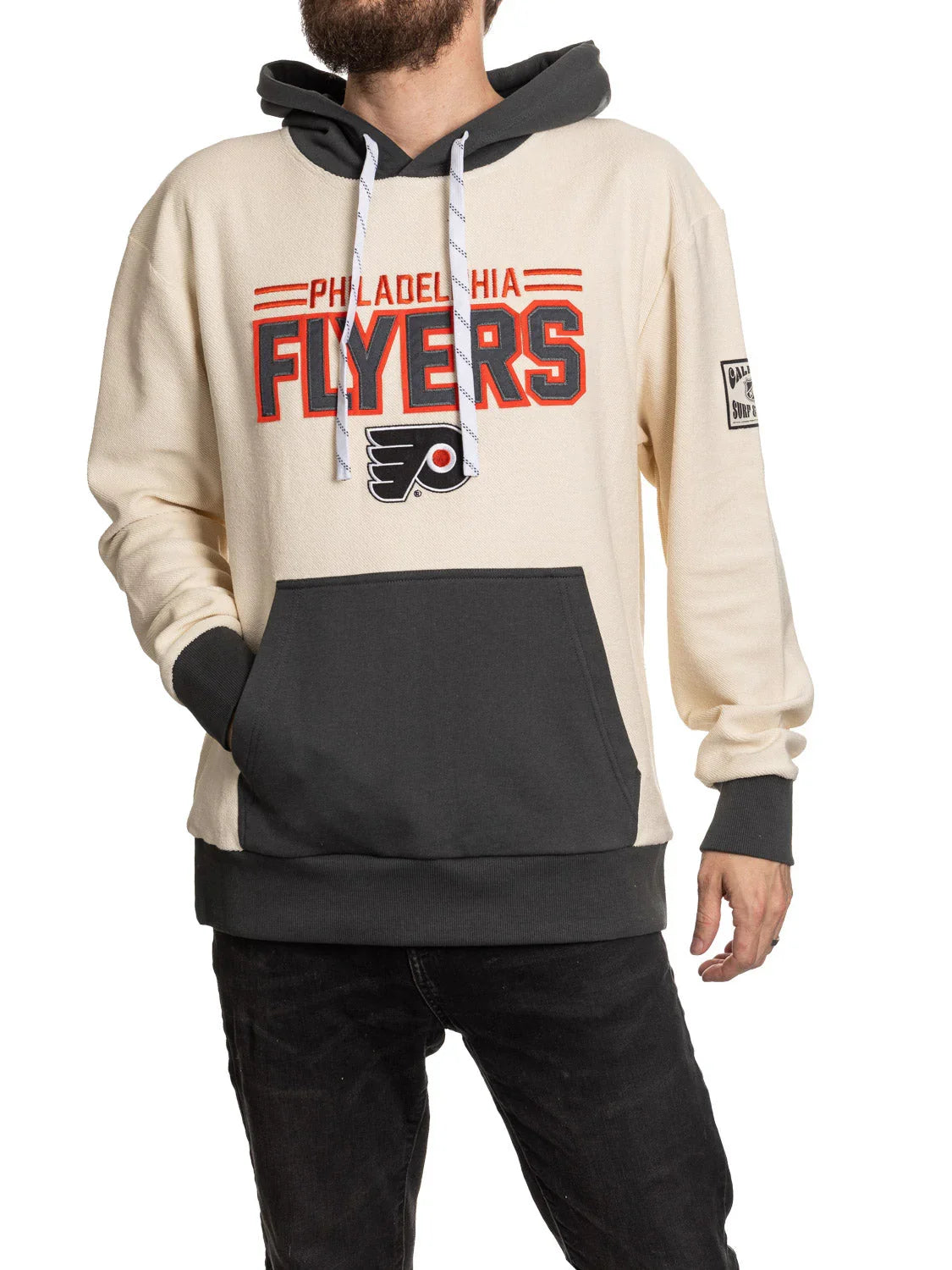 Man wearing cream and black Philadelphia Flyers hoodie with team logo and kangaroo pocket