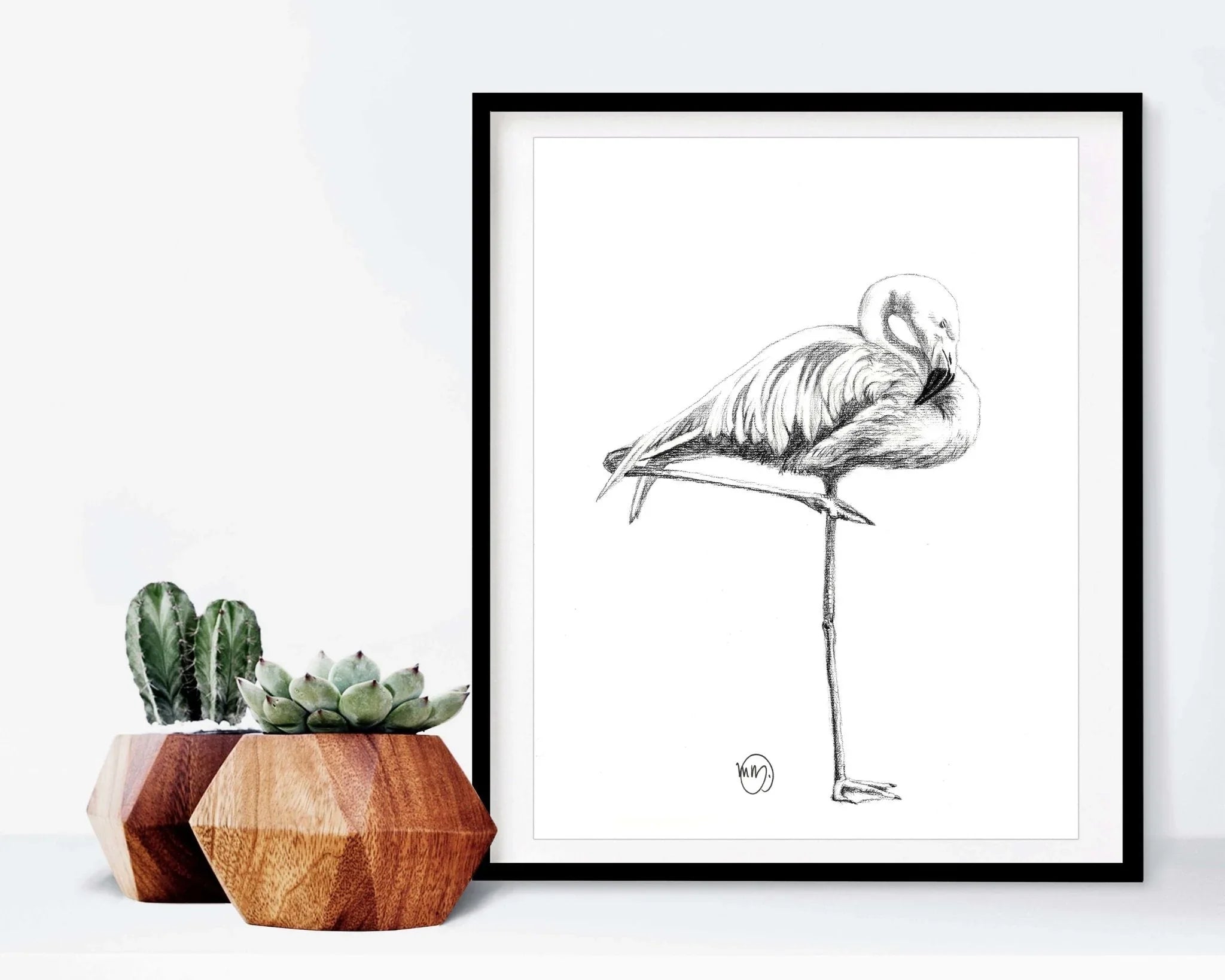 Framed flamingo sketch art print beside geometric wooden planters with succulents
