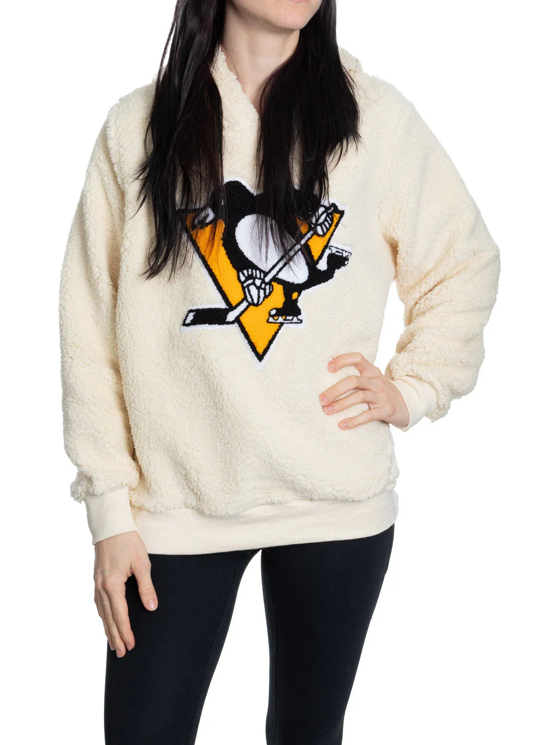 Woman wearing cream sherpa pullover with Pittsburgh Penguins hockey logo on front