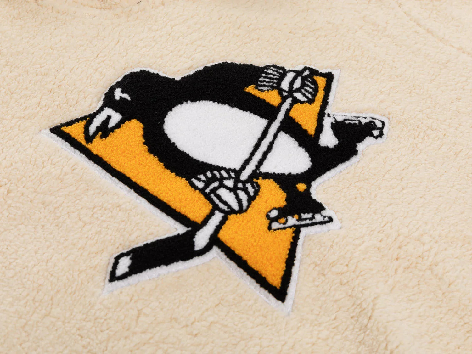 Pittsburgh Penguins logo patch on cream sherpa fleece fabric