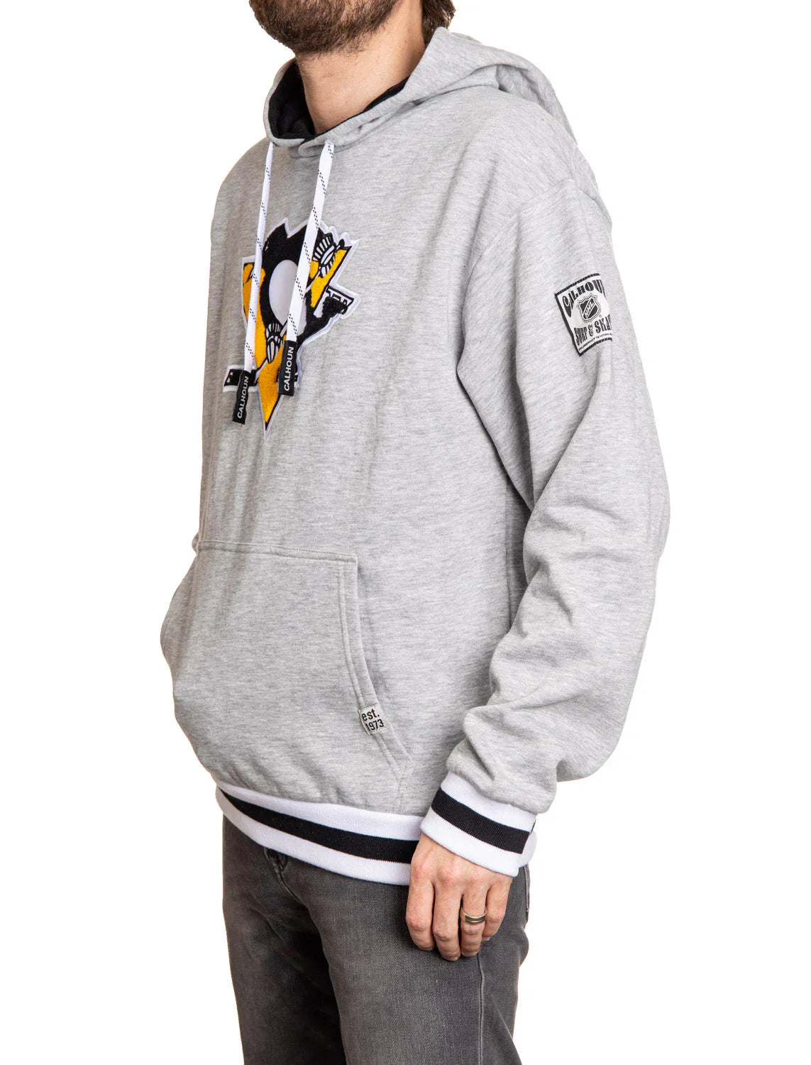 Man wearing grey Pittsburgh Penguins chenille patch hoodie with logo and striped cuffs