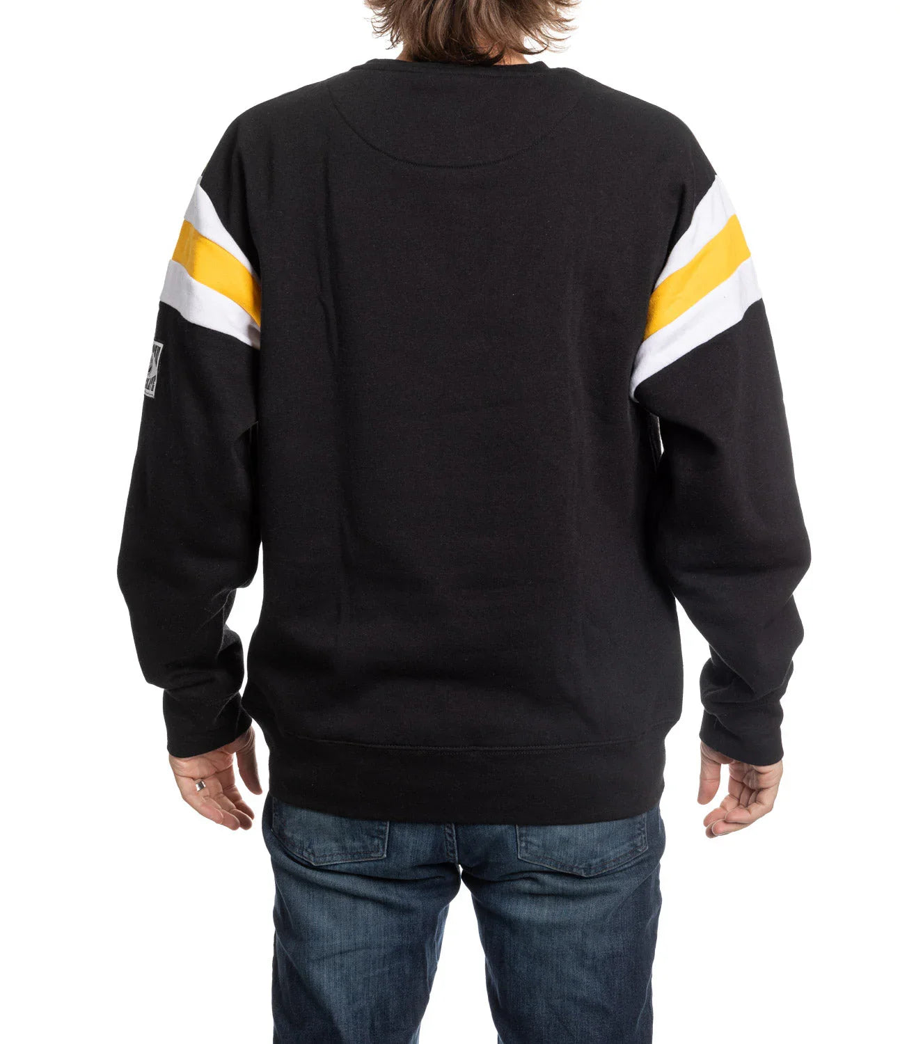 Back view of black varsity sweater with yellow and white stripes on sleeves, worn with jeans