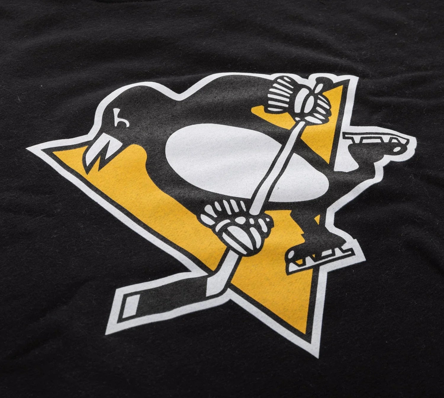 Penguin hockey logo on black varsity crew sweatshirt, yellow triangle background