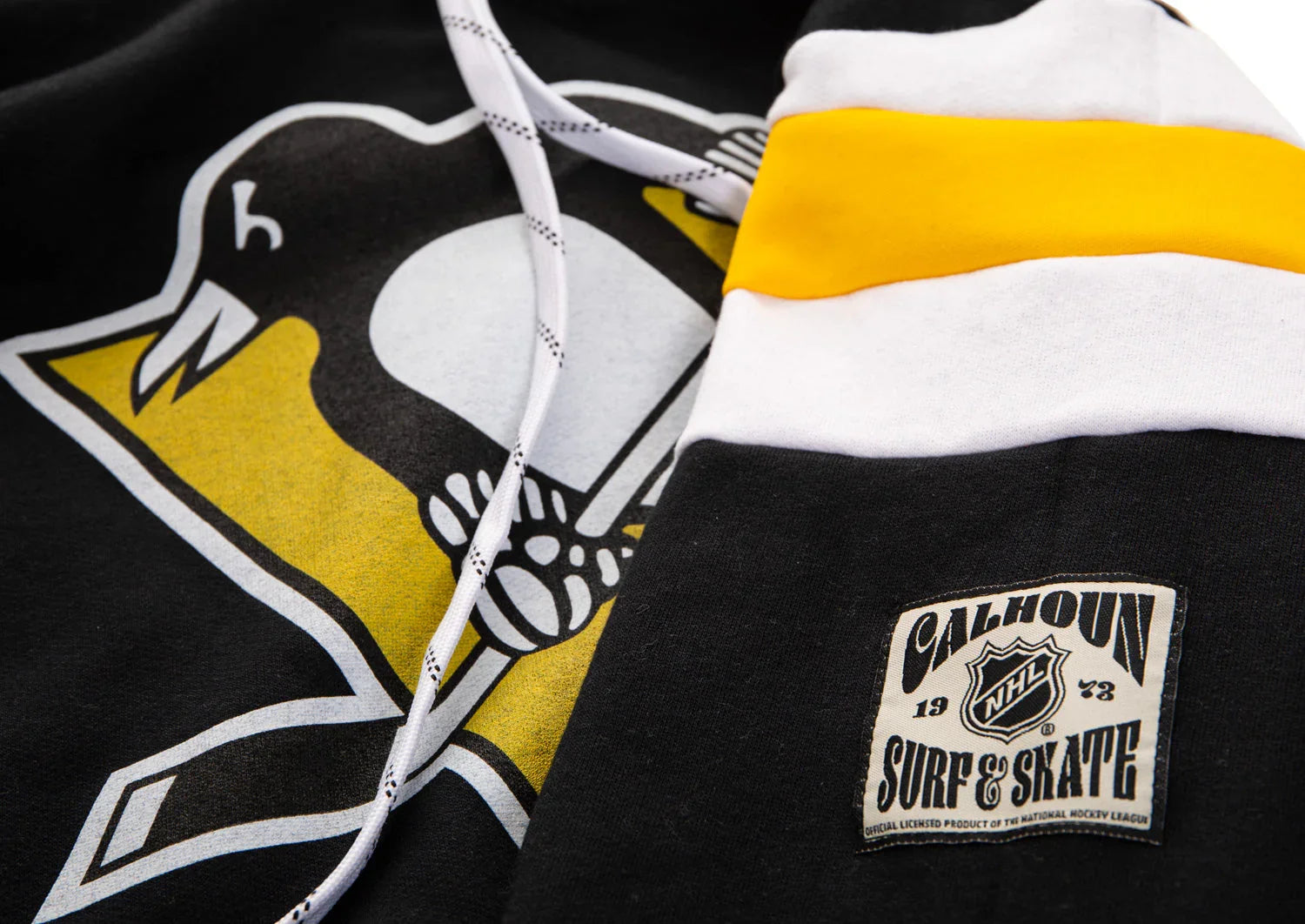 Close-up of Pittsburgh Penguins NHL hoodie with Calhoun Surf & Skate patch and drawstrings