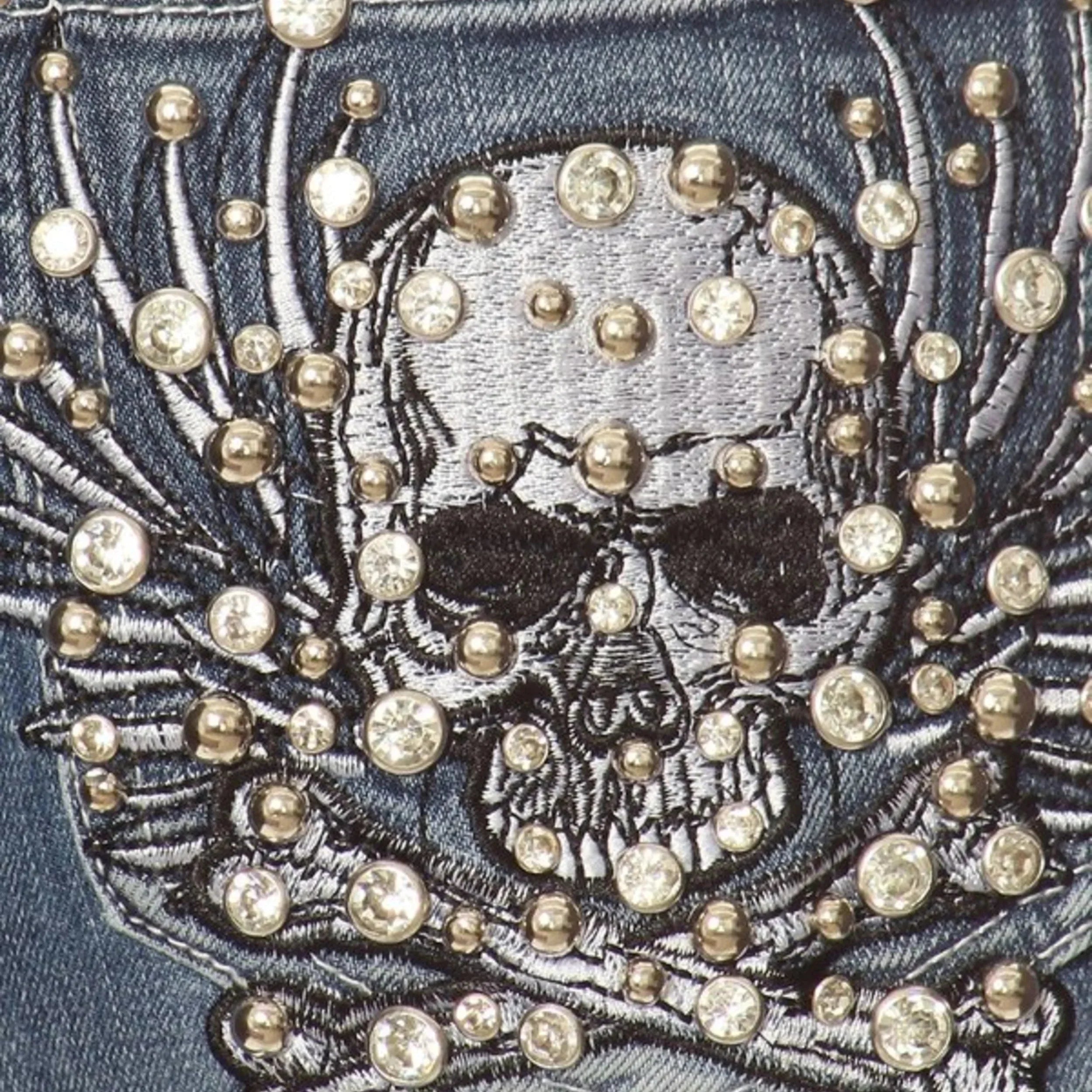Embroidered skull on denim with silver studs and rhinestone embellishments