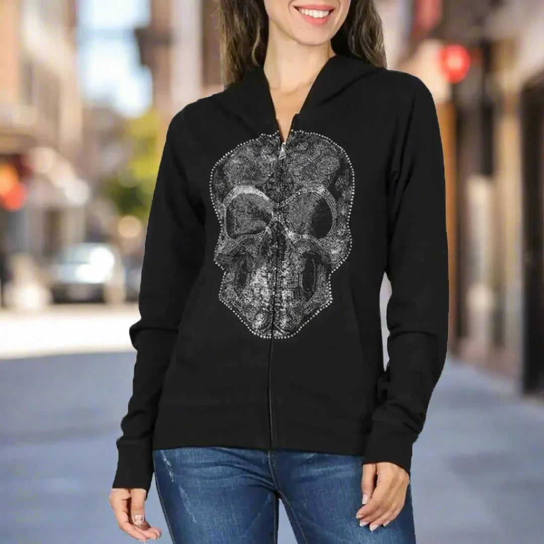 Woman wearing black full zip hoodie with rhinestone skull design outdoors
