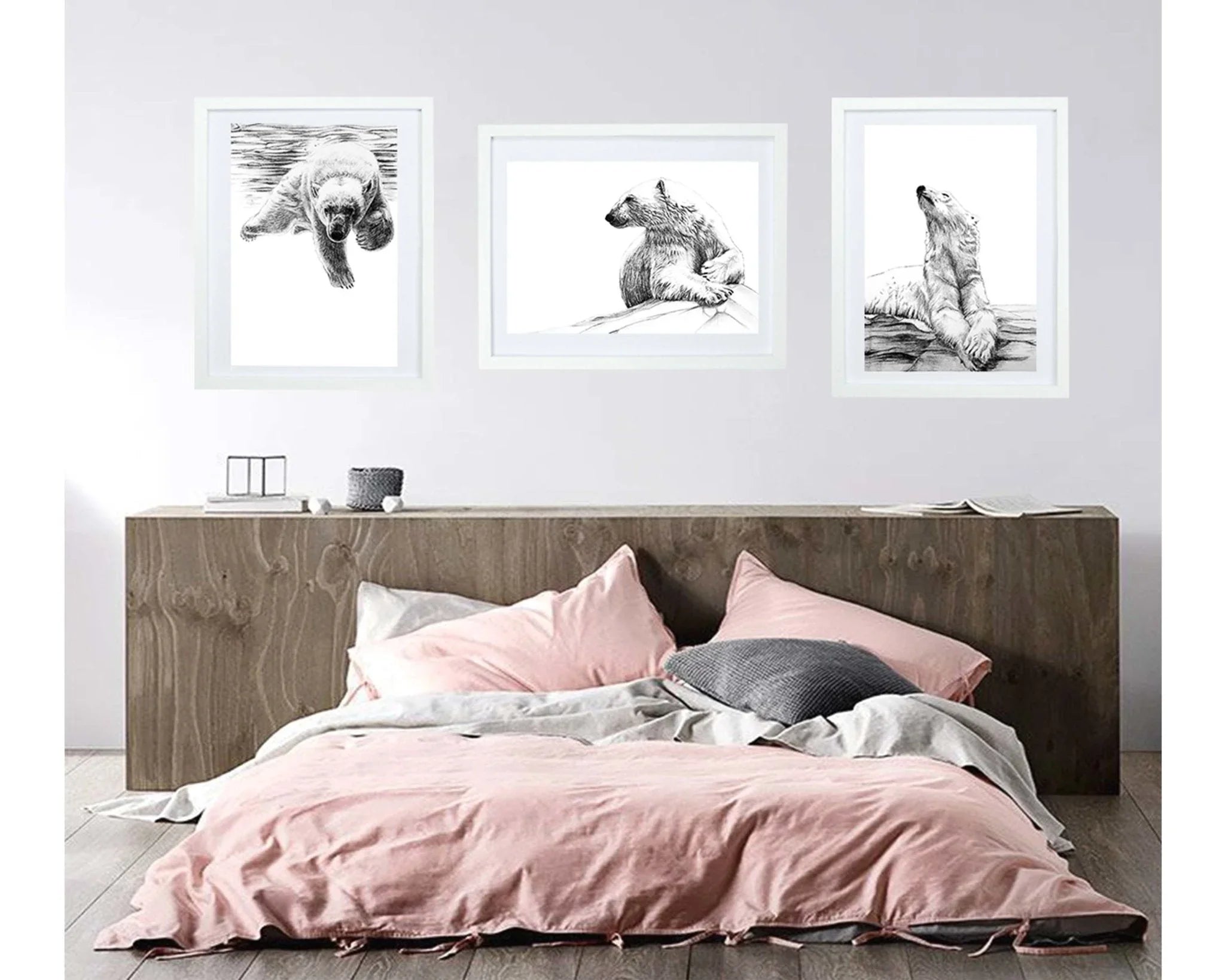 Cozy bedroom with pink bedding, wood headboard, and polar bear art prints on white wall