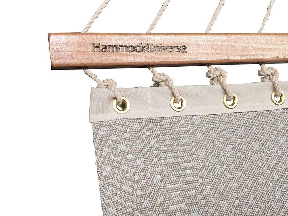 Closeup of sand-colored poolside double hammock with wood spreader bar and rope loops