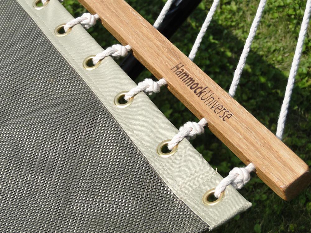 Close-up of Hammock Universe spreader bar and mesh hammock on green grass outdoors