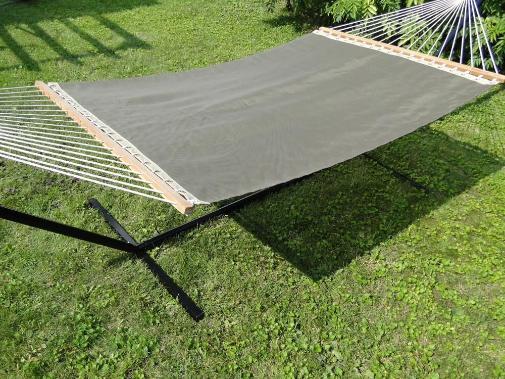Outdoor hammock with black metal stand on green grass lawn