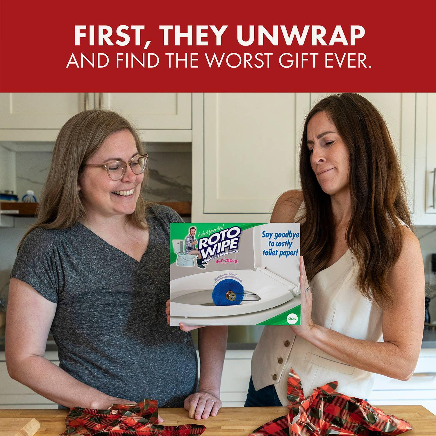 Two women in a kitchen holding a Roto Wipe prank gift box, smiling and laughing