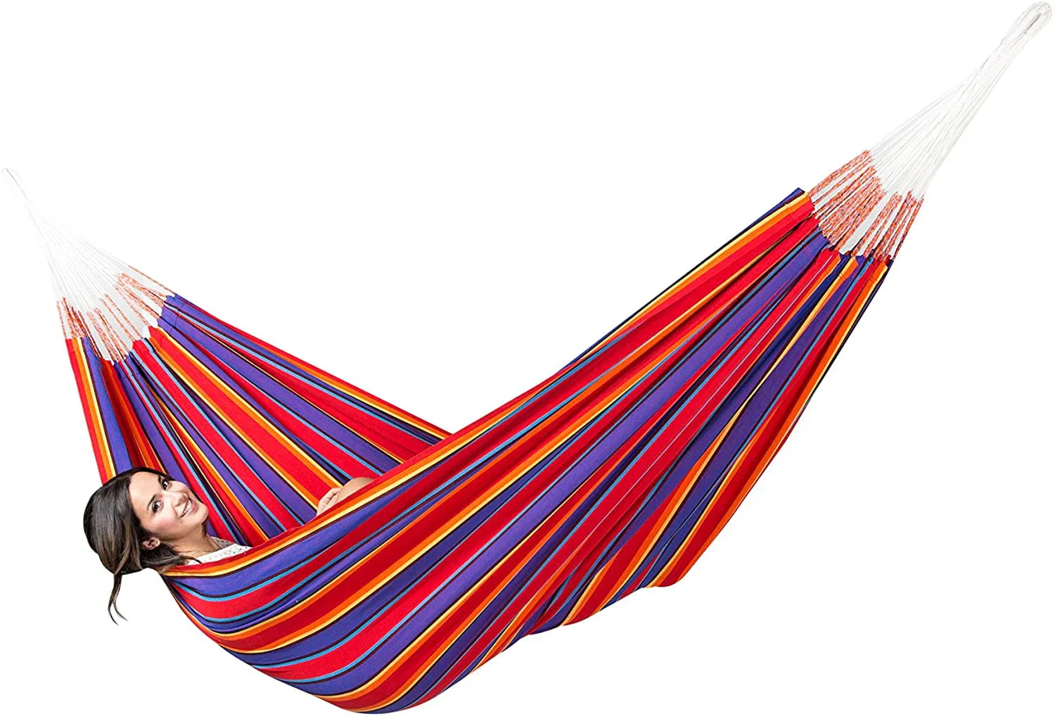 Woman relaxing in a colorful Yagua Morada striped hammock, isolated on white background