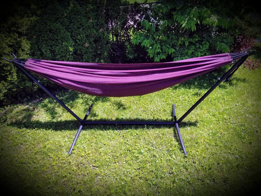 Brazilian double hammock in pink and black on metal stand outdoors on green grass