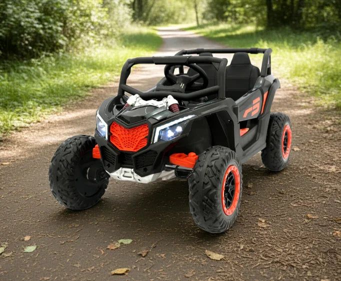 Black and red kids ride-on toy car with LED headlights on a forest path