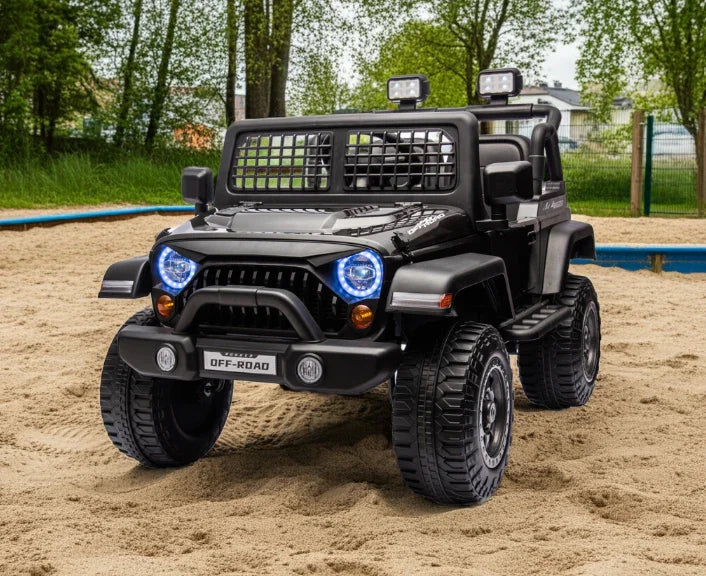 Black off-road toy car with LED headlights on sand playground, outdoor ride on jeep
