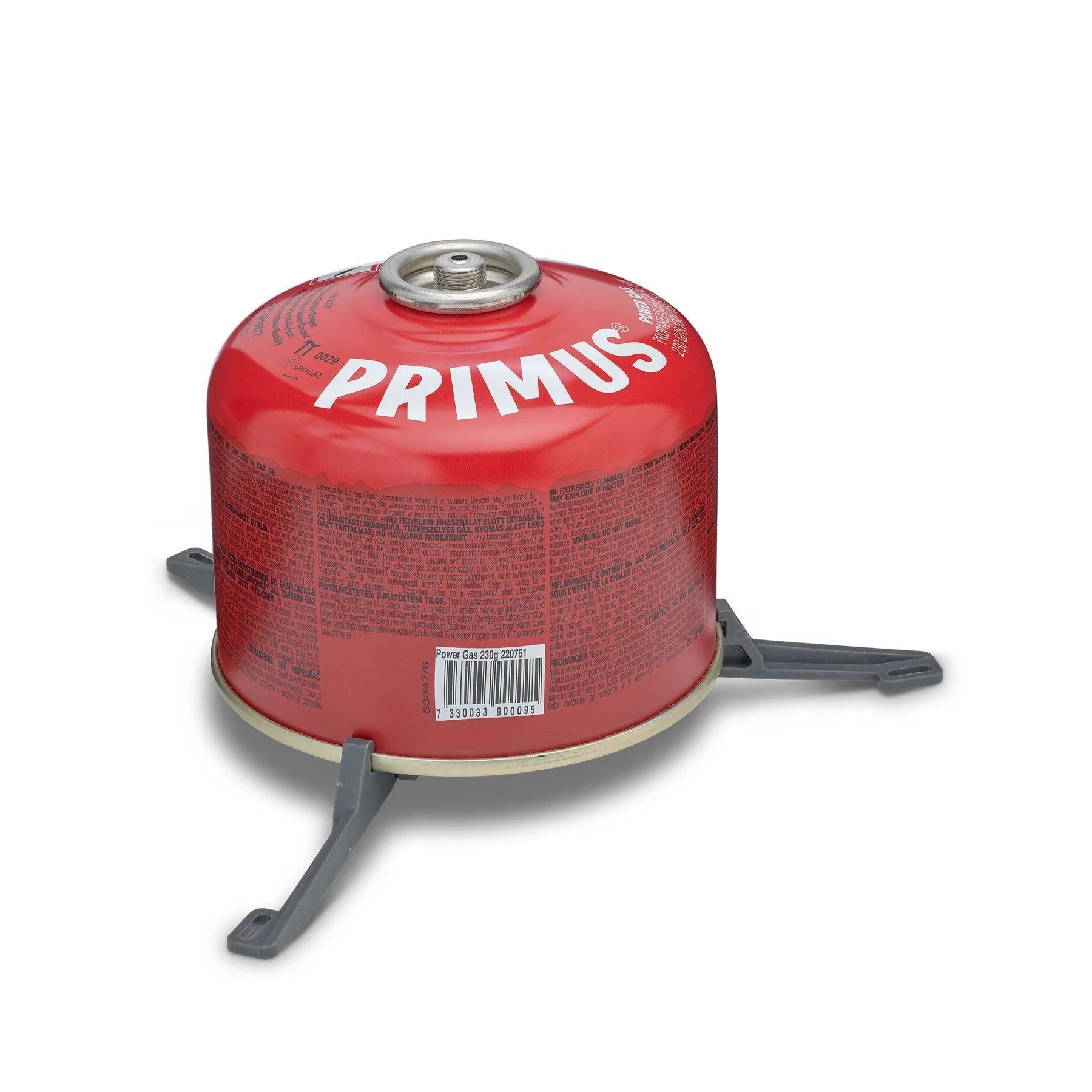 Primus red fuel canister on gray stand for camping stoves, isolated on white background