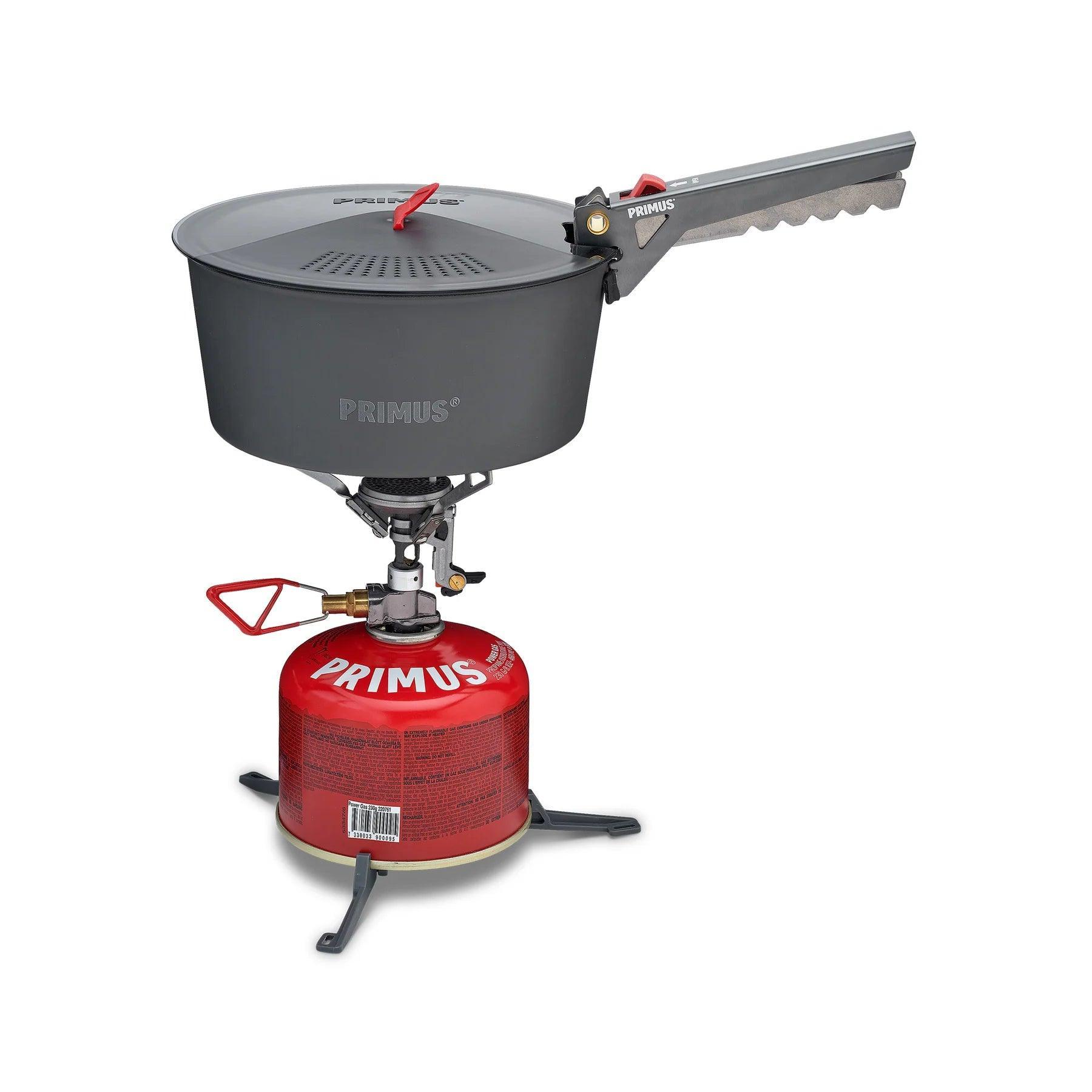 Primus camping stove with red fuel canister and gray cook pot on white background